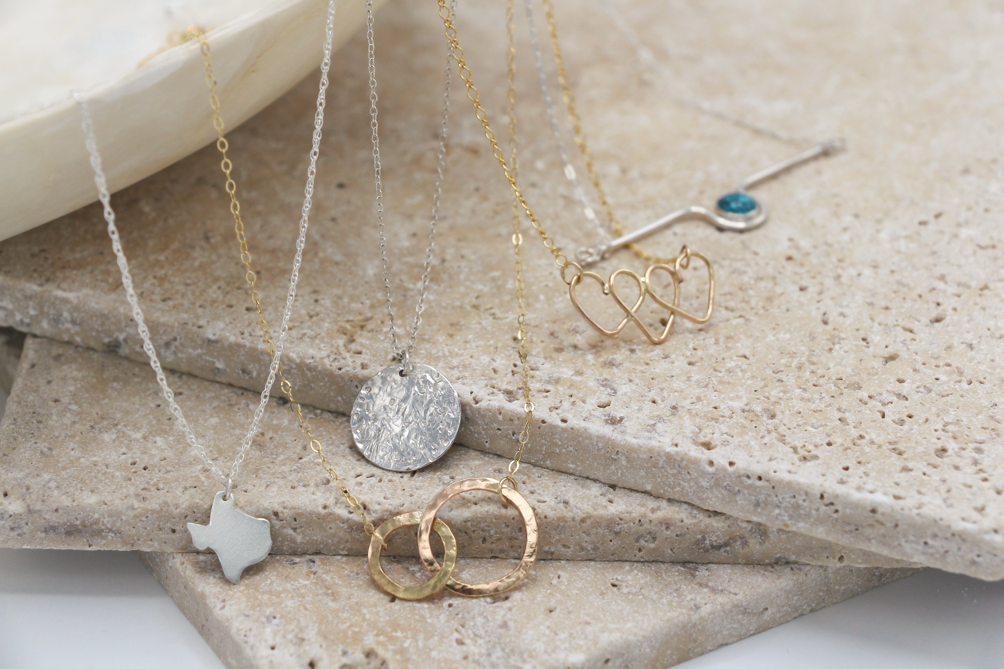 A variety of handmade dainty everyday necklaces in sterling silver and gold