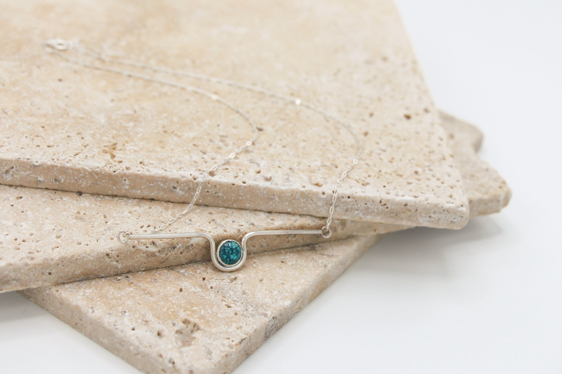 Sterling Silver dainty chain necklace with a bezel set turquoise in the middle of a wave-like bar.